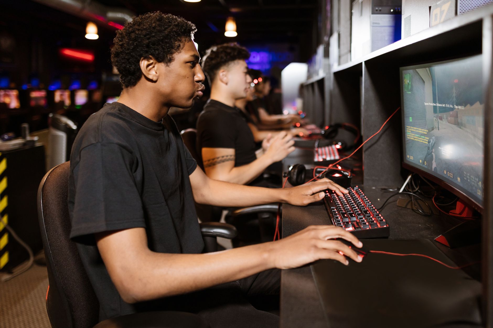 Young male gamer at an RGB-lit computer setup with a monitor showing a gaming profile screen, where a bold, edgy username is prominently displayed to represent a stylish attitude boy name.